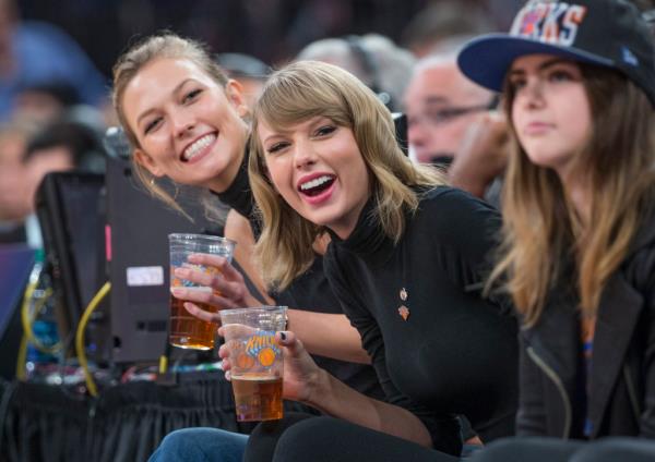 Karlie Kloss and Taylor Swift smiling together. 