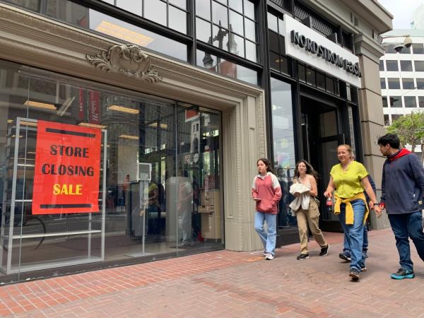 A family walks past a Nordstrom with a 