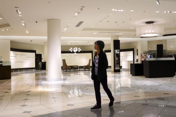 A woman is seen strolling through the empty store.