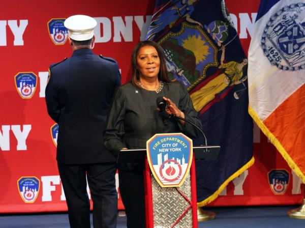 Attorney General Letitia James speaking at FDNY Promotion Ceremony with John Hodgens and Laura Kavanagh standing behind her.
