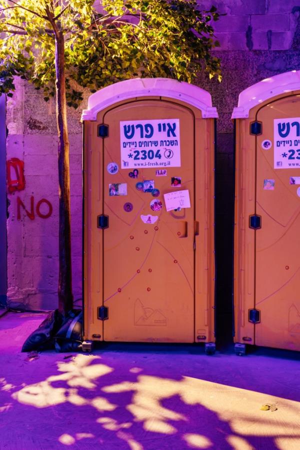 A porta potty riddled with bullet holes.