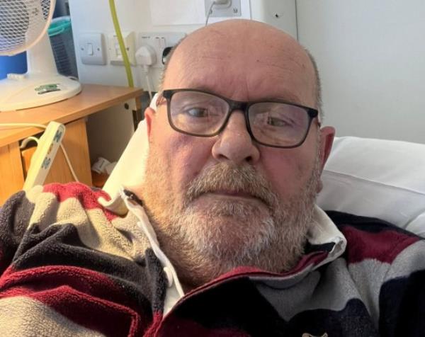 David Lindsay sit up in hospital bed. 