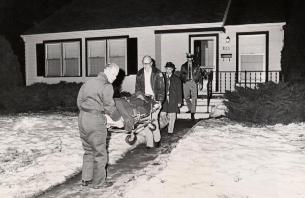 The body of the one of the Otero family members – Rader's first known victims – are removed from the house in 1974.