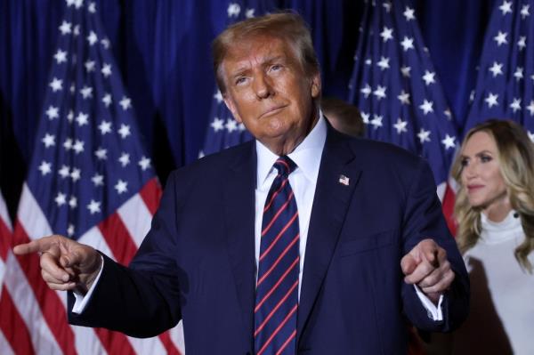 Former U.S. President Do<em></em>nald Trump gesturing on stage during his New Hampshire primary election night watch party, after clinching the 2024 Republican nomination.