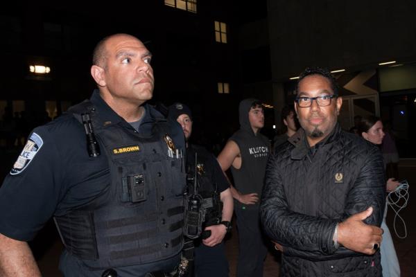 George Washington University Provost Christopher Bracey, right, is escorted by school police after students protesting the Israel-Hamas war broke through police fencing to occupy the school's University Yard.