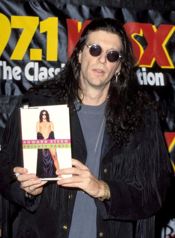 Howard Stern holds his 1993 memoir, 