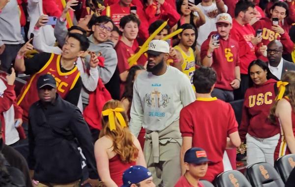 LeBron James leads hid family through massive student filled crowd as they watched Bro<em></em>nny James' first college basketball game.