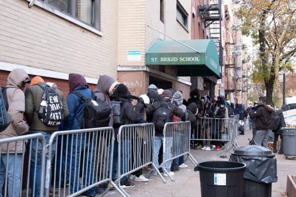 Migrants line up outside the Brigid School to try and find housing in city shelters.</p>

<p>　　