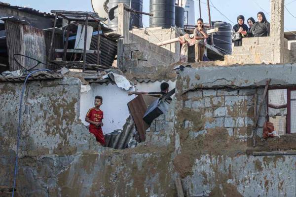Palestinians react to the damage after an Israeli military strike on the Rafah refugee camp, in the southern of Gaza Strip on Sunday