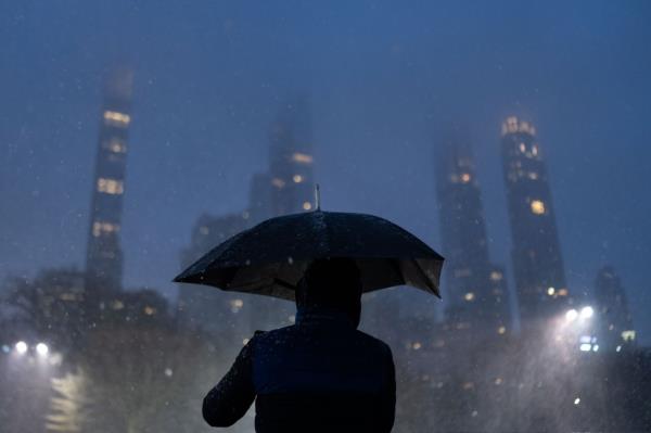 A person takes a photograph of snowfall in Central Park in New York City on January 6.