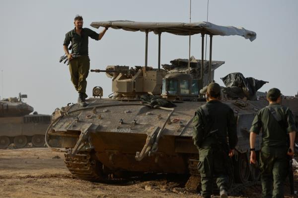 An Israeli soldier stands on an armored perso<em></em>nnel carrier near the Israel-Gaza border on its Israeli side during a temporary truce between Hamas and Israel.