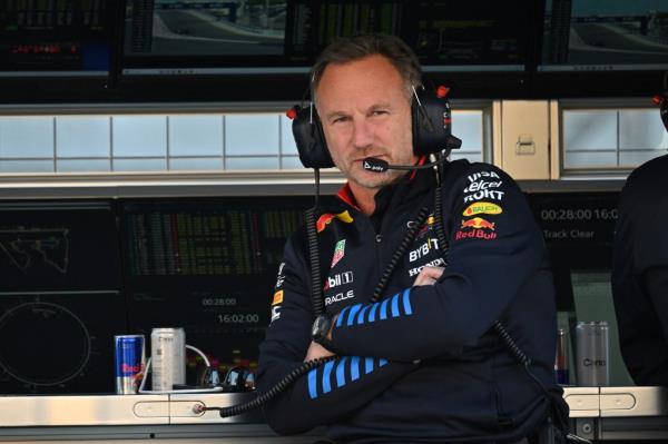 Christian Horner, wearing headpho<em></em>nes and a racing suit