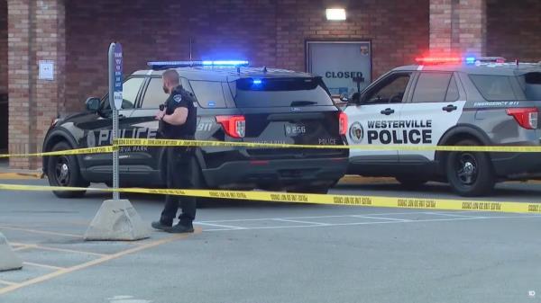 A police officer is pictured with police vehicles outside of the Kroger.