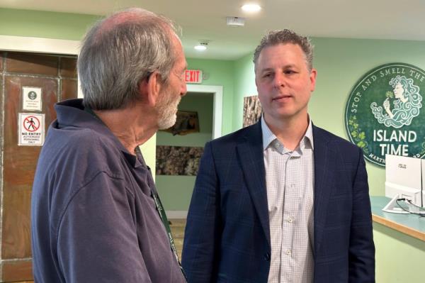 Geoff Rose, the owner of Island Time cannabis dispensary, discussing with lawyer Adam Fine in his store in Vineyard Haven, Mass.