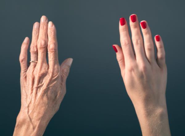 A young hand and an older hand. 