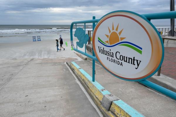 People walking past an access ramp at New Smyrna Beach, Volusia County, Florida, known for the highest rate of shark attacks globally, on February 23, 2024.