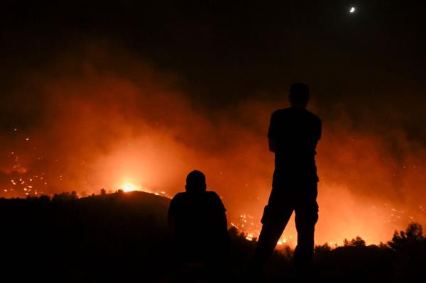 People watch the fires near the village of Malona in the Greek island of Rhodes on July 23, 2023.</p>

<p>　　