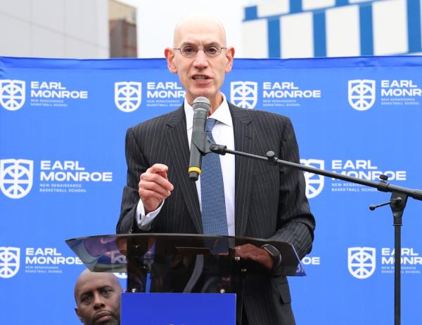 NBA Commissio<em></em>ner Adam Silver speaking in front of a podium,