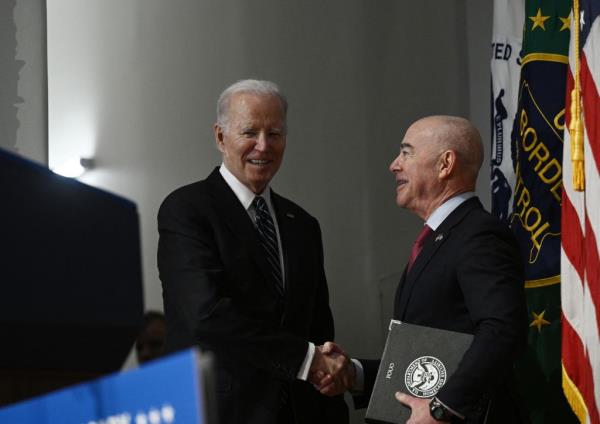 Homeland Security Secretary Alejandro Mayorkas shakes hands with President Joe Biden