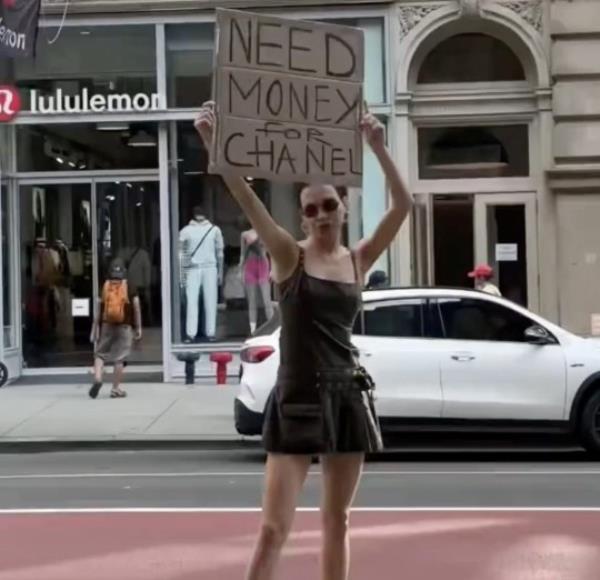Karolina Getis holds up a 'need mo<em></em>ney for Chanel' sign on the streets of NYC in one of her fun TikToks.