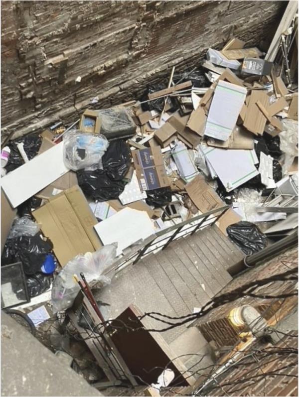 South Air Shaft at 218 Thompson St. showing poor co<em></em>nditions with a pile of cardboard boxes on a staircase, photographed for the Tran Tenant Coalition press release in 2024.