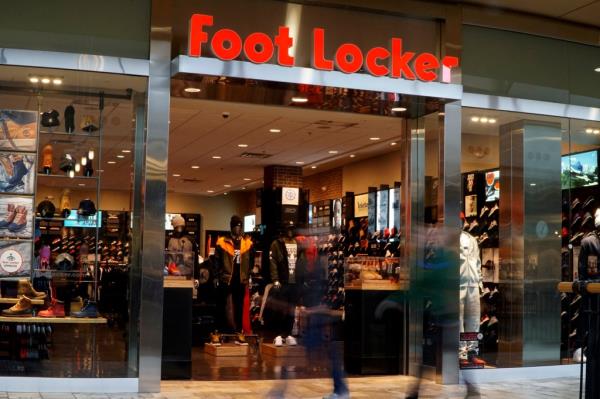Customers in mall walk by Foot Locker store.