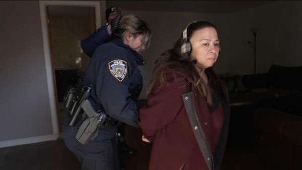 Adele Andaloro is seen being led away by police.