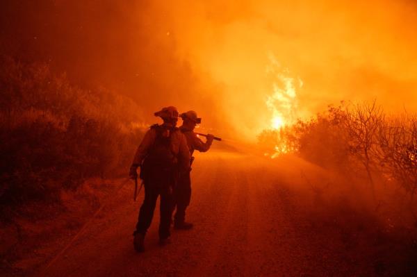 Firefighters work against the advancing Post Fire 