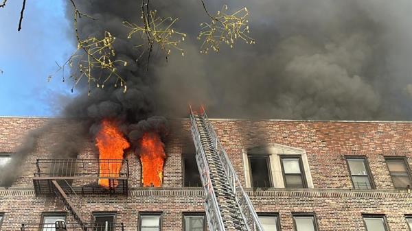 Flames and smoke billow out of the window during the fire at 43-09 47th Avenue in Queens.
