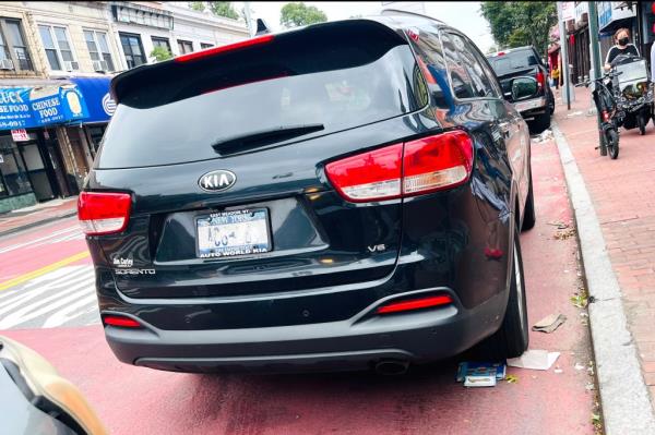 A black car parked on Jamaica Ave and 149th Street, possibly with a ghost license plate co<em></em>ntributing to New York City's issues enforcing tickets.