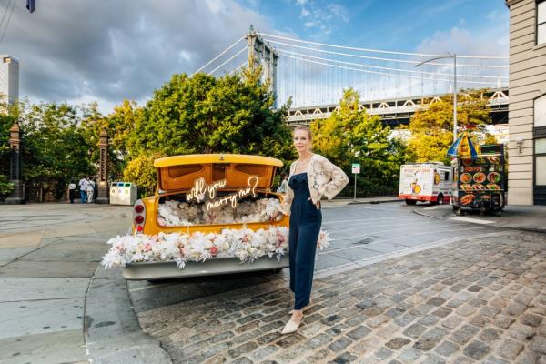 Chandler Fowles of Enchanting Engagements, photographed in DUMBO, Brooklyn with her wedding taxi. 