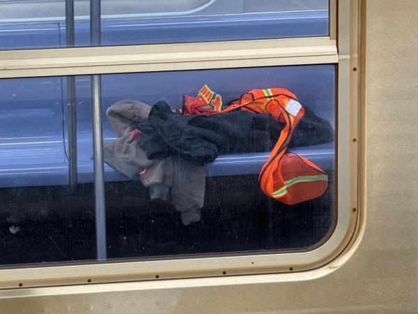 Co<em></em>nstruction vest and clothes lay on subway seat