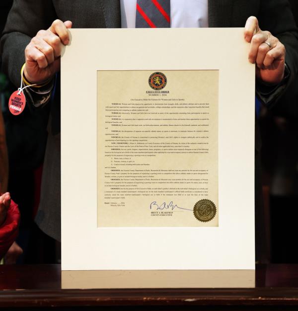Nassau County Executive Bruce Blakeman holding an executive order, surrounded by children, at a press co<em></em>nference announcing a plan related to sports teams in Theodore Roosevelt Building, Mineola, Long Island, NY.