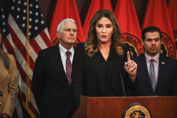 Caitlyn Jenner, former Olympic gold medalist, speaking at a podium a<em></em>bout trans athlete legislation while Nassau County Executive Bruce Blakeman stands in the background
