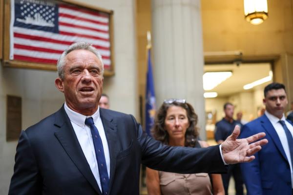 Robert F. Kennedy Jr. walking in the hallway of the Supreme Courthouse in Mineola, NY, dressed in a suit and tie