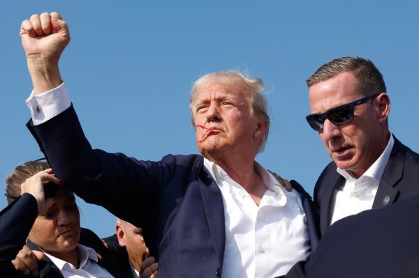 Do<em></em>nald Trump pumps his fist in defiance after surviving an assassination attempt last month.