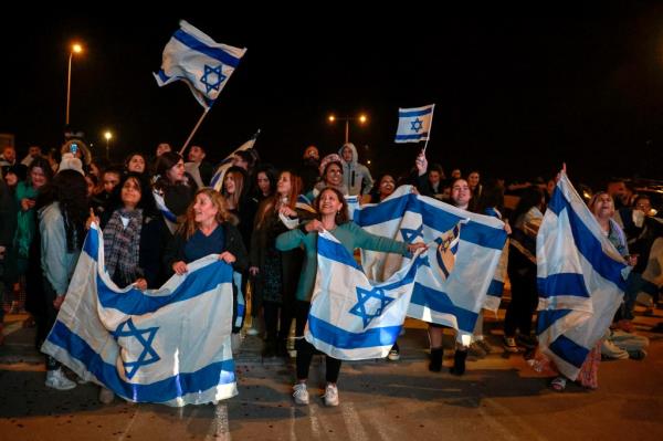 Israel supporters hold flags as Israeli hostages arrive at Ofakim army ba<em></em>se in southern Israel early on Nov. 30, 2023.