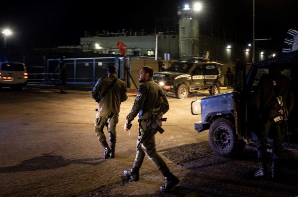 Israeli soldiers walk outside a military prison in the occupied West Bank on Nov. 30, 2023, hours before the cease-fire was set to expire.