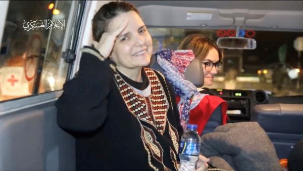 One of the newly released hostages salutes the camera as they are handed over to the Internatio<em></em>nal Red Cross before being transported back to Israel from the Gaza Strip.