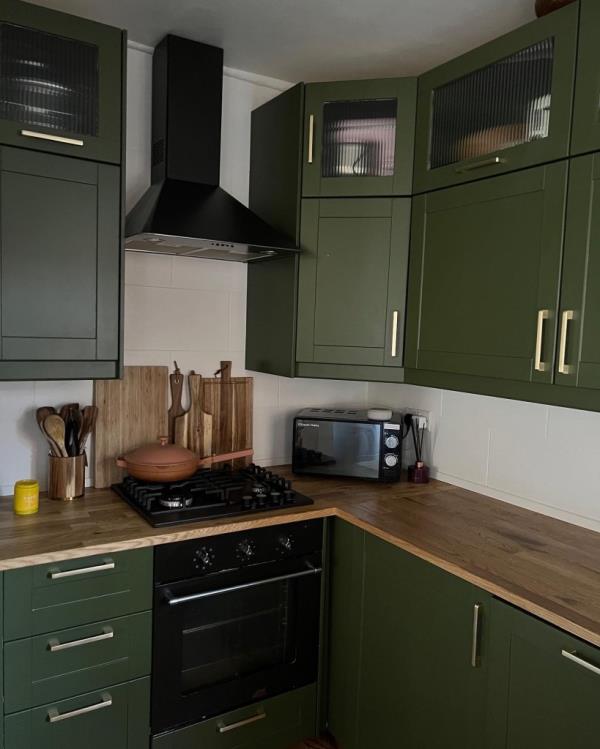 Photo of an olive green kitchen. 