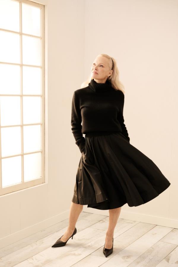 Pamela Anderson posing in a black dress