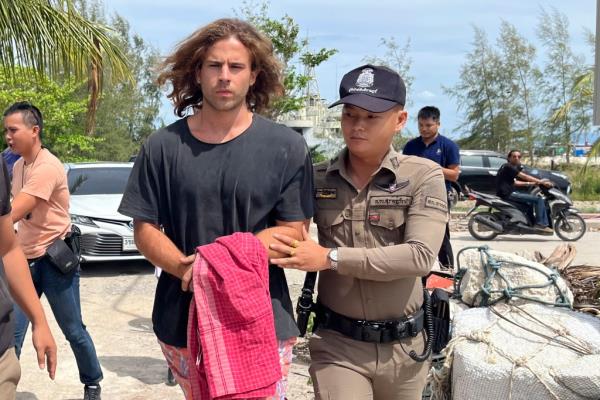 A Thai police officer escorts Spanish Daniel Sancho Bro<em></em>nchalo on suspicion of murdering and dismembering a Colombian surgeon from Koh Phagnan island to Koh Samui Island court, southern Thailand, Monday, Aug. 7, 2023