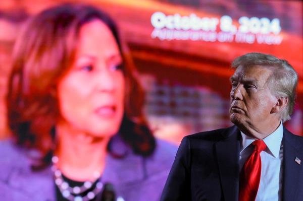 Do<em></em>nald Trump looks on as a screen shows Democratic presidential nominee U.S. Vice President Kamala Harris during a campaign rally at Macomb Community College in Warren, Michigan, U.S., November 1, 2024. 