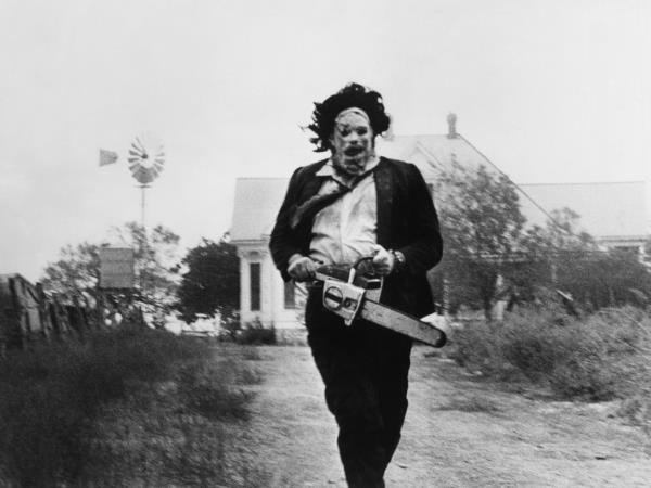Gunnar Hansen as Leatherface wielding a chainsaw