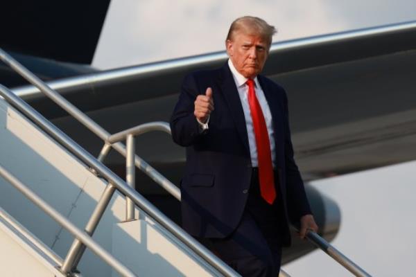 Former U.S. President Do<em></em>nald Trump gives a thumbs up as he arrives at Atlanta Hartsfield-Jackson Internatio<em></em>nal Airport on August 24, 2023 in Atlanta, Georgia. Trump is expected to surrender at the Fulton County jail, wher<em></em>e he will be booked on 13 charges related to an alleged plan to overturn the results of the 2020 presidential election in Georgia.