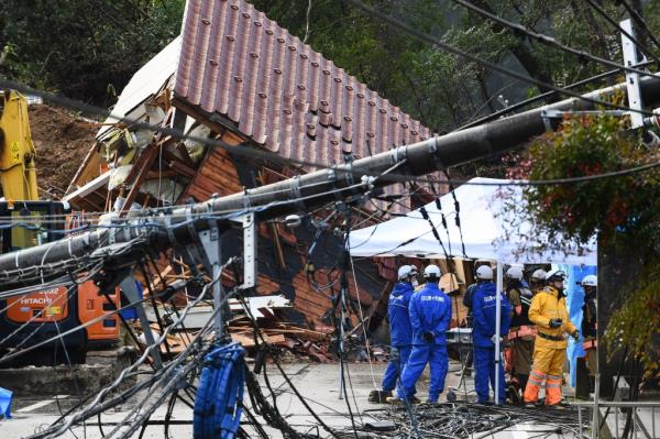 A downed power pole lies across a street as rescue crews search for missing victims near the site of a landslide on Jan. 6, 2024.