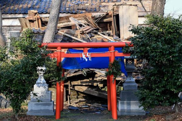 A torii, or shrine's gate. stands in front of a damaged building in Wajima, Japan following the 7.6 magnitude earthquake.