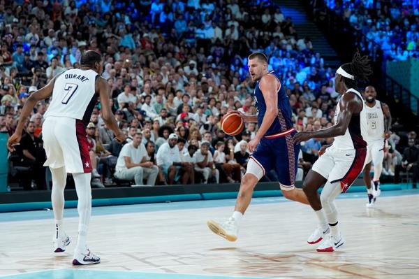 Nikola Jokic of Serbia attacks the basket against Kevin Durant (L) and Jrue Holiday (R) of the United States during the Men's Semifinal Game between United States and Serbia on day thirteen of the Olympic Games Paris 2024 at Arena Bercy on August 8, 2024 in Paris, France. 