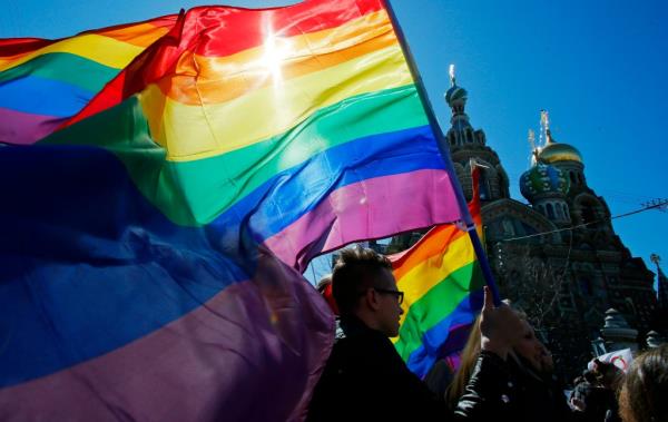 Gay rights activists carry rainbow flags as they march during a May Day rally in St. Petersburg, Russia, Wednesday, May 1, 2013.