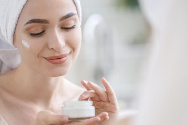 A woman applying anti-aging cream to her face